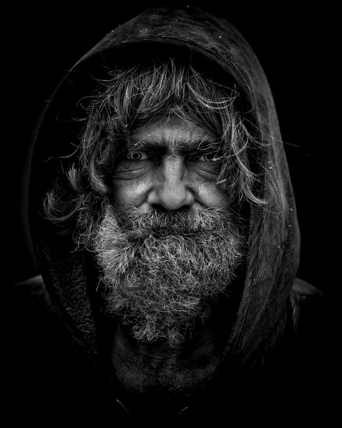 Emotive black and white portrait of an elderly man with a rugged appearance.